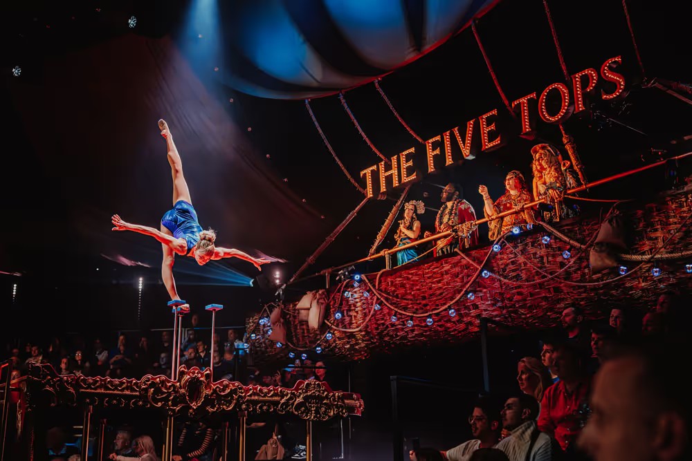 Acrobats balancing on raised pedestals in COME ALIVE!